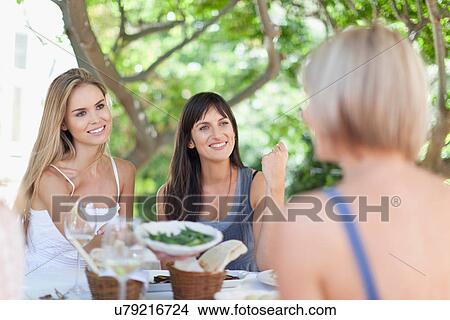 Women eating at table outdoors View Large Photo Image Picture - Women eating at table outdoors. Fotosearch