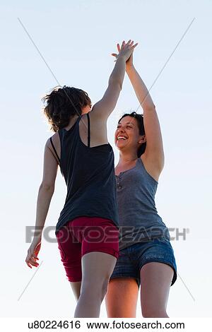 Women high-fiving outdoors View Large Photo Image Stock Photograph - Women high-fiving outdoors. Fotosearch