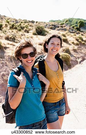 Stock Image - Women hiking together on hill. Fotosearch