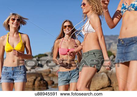 Women in bikinis walking on beach View Large Photo Image Stock Image - Women in bikinis walking on beach. Fotosearch