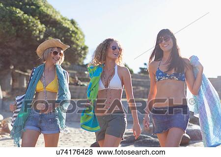 Women in bikinis walking on beach View Large Photo Image Stock Photo - Women in bikinis walking on beach. Fotosearch