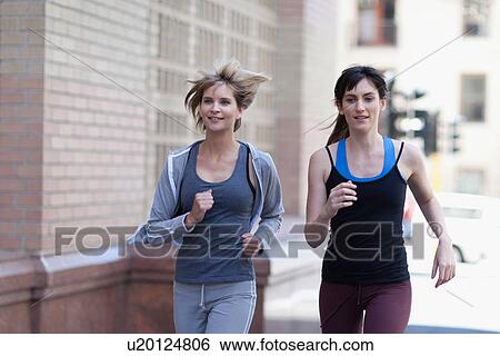 Women running together on city street View Large Photo Image Stock Photograph - Women running together on city street. Fotosearch