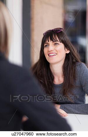 Stock Image - Women sitting in cafe together. Fotosearch