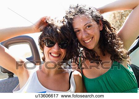 Women smiling together in convertible View Large Photo Image Stock Photo - Women smiling together in convertible. Fotosearch