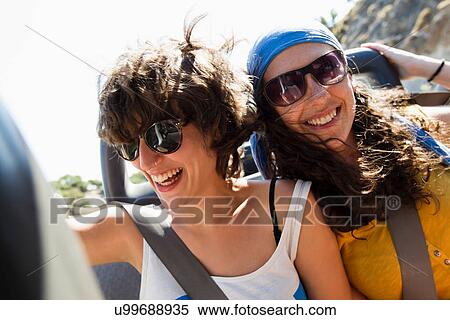 Women smiling together in convertible View Large Photo Image Stock Photography - Women smiling together in convertible. Fotosearch