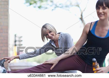 Stock Image - Women stretching before workout outdoors. Fotosearch