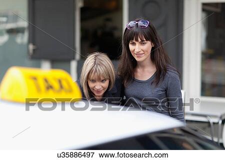 Women taking taxi cab in city View Large Photo Image Stock Photo - Women taking taxi cab in city. Fotosearch