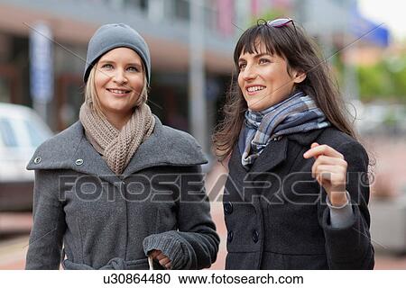 Women talking on city street View Large Photo Image Stock Image - Women talking on city street. Fotosearch