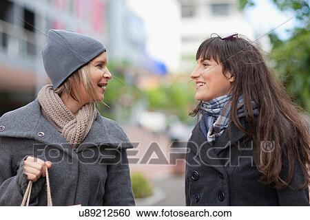 Stock Image - Women talking on city street. Fotosearch