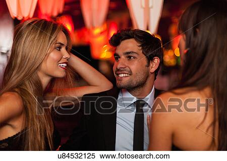 Stock Photography - Women talking with man in bar. Fotosearch