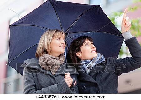 Women under umbrella on city street View Large Photo Image Stock Image - Women under umbrella on city street. Fotosearch