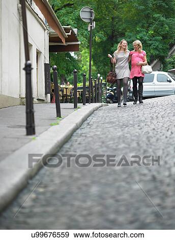 Women walking on cobbled street View Large Photo Image Stock Photo - Women walking on cobbled street. Fotosearch