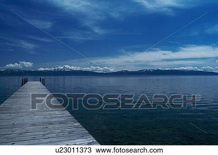 Stock Image - Wooden dock in still lake. Fotosearch