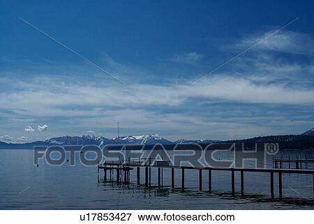Stock Photo - Wooden dock in still lake. Fotosearch