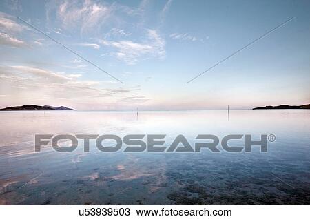 Stock Image - Wooden poles in still lake. Fotosearch