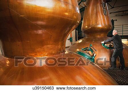 Worker in whisky distillery View Large Photo Image Stock Image - Worker in whisky distillery. Fotosearch