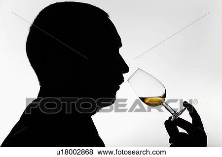 Stock Photo - Worker smelling whisky in distillery. Fotosearch