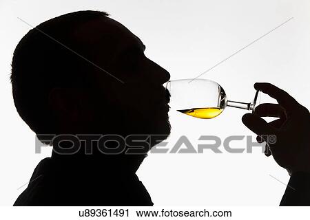 Stock Image - Worker tasting whisky in distillery. Fotosearch