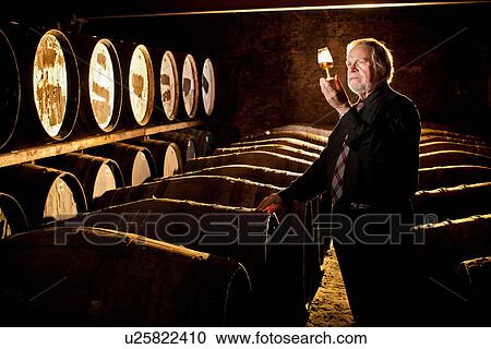 Worker testing whisky in distillery View Large Photo Image Stock Image - Worker testing whisky in distillery. Fotosearch