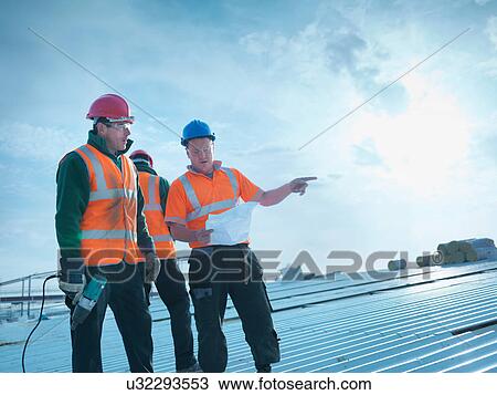 Workman and apprentice discussing plans on factory roof View Large Photo Image Stock Image - Workman and apprentice discussing plans on factory roof. Fotosearch