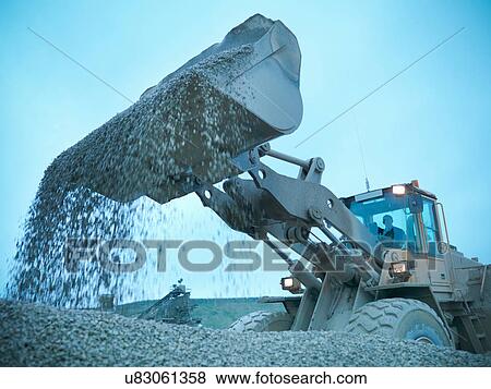 Workman moving stones with industrial digger on quarry site View Large Photo Image Stock Photo - Workman moving stones with industrial digger on quarry site. Fotosearch