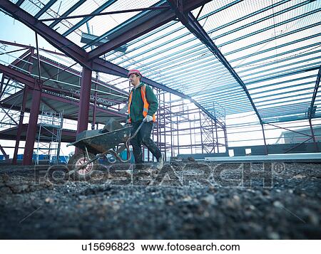 Workman pushing wheelbarrow beneath steel construction frame on building site View Large Photo Image Stock Image - Workman pushing wheelbarrow beneath steel construction frame on building site. Fotosearch