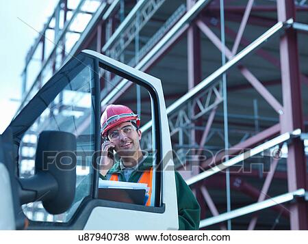 Workman using moble phone by van and steel construction frame on building site View Large Photo Image Stock Photo - Workman using moble phone by van and steel construction frame on building site. Fotosearch
