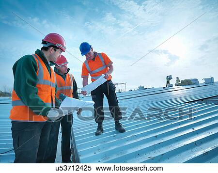 Workmen and apprentice discussing plans on factory roof View Large Photo Image Stock Photography - Workmen and apprentice discussing plans on factory roof. Fotosearch