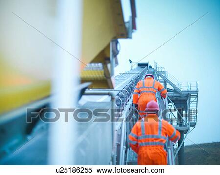 Workmen in reflective clothing climbing steps of screening conveyor at quarry View Large Photo Image Stock Photography - Workmen in reflective clothing climbing steps of screening conveyor at quarry. Fotosearch