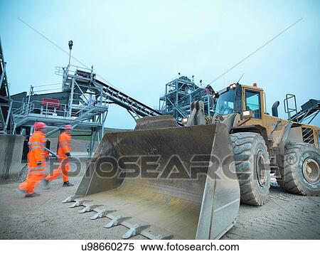 Workmen walking towards digger on quarry site View Large Photo Image Stock Photography - Workmen walking towards digger on quarry site. Fotosearch