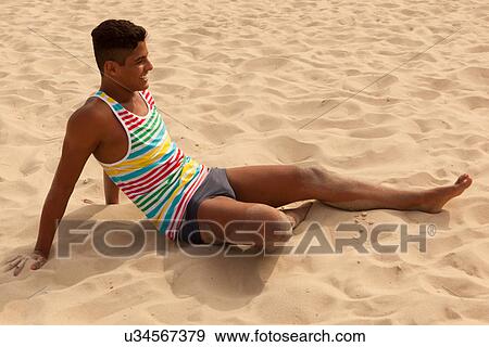 Young man relaxing on beach View Large Photo Image Stock Photo - Young man relaxing on beach. Fotosearch