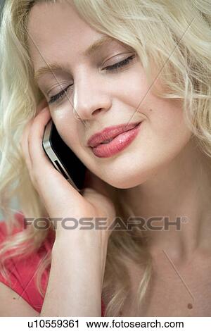 Young woman on cellphone with eyes closed View Large Photo Image Stock Image - Young woman on cellphone with eyes closed. Fotosearch