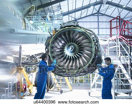 Aircraft engineers working on jet engine in aircraft maintenance factory View Large Photo Image Stock Photograph - Aircraft engineers working on jet engine in aircraft maintenance factory. Fotosearch