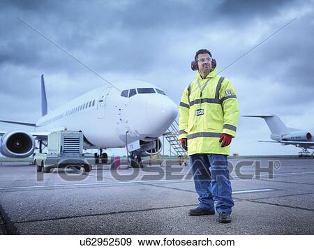 Stock Photo - "Airport worker on runway, portrait". Fotosearch
