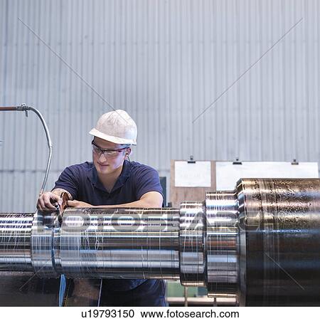 Apprentice working on lathe in engineering factory View Large Photo Image Stock Image - Apprentice working on lathe in engineering factory. Fotosearch