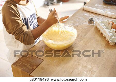 Boy beating mixture in bowl in kitchen View Large Photo Image Stock Photograph - Boy beating mixture in bowl in kitchen. Fotosearch