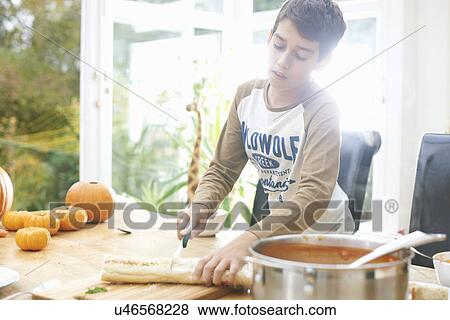 Boy preparing baguette and pumpkin soup in kitchen View Large Photo Image Stock Photo - Boy preparing baguette and pumpkin soup in kitchen. Fotosearch