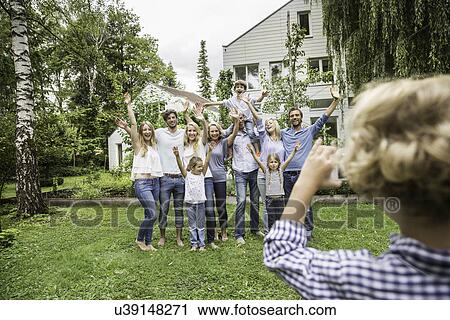 Boy taking photo of three generational family in garden View Large Photo Image Stock Image - Boy taking photo of three generational family in garden. Fotosearch