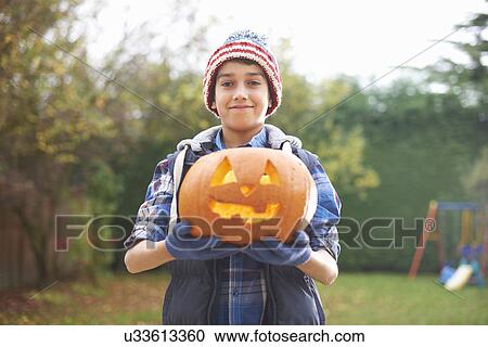 Boy with pumpkin posing in garden View Large Photo Image Stock Image - Boy with pumpkin posing in garden. Fotosearch
