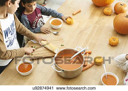 Brothers and sister preparing baguette and pumpkin soup in kitchen View Large Photo Image Stock Image - Brothers and sister preparing baguette and pumpkin soup in kitchen. Fotosearch