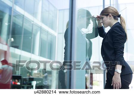 Businesswoman peering through glass window View Large Photo Image Picture - Businesswoman peering through glass window. Fotosearch
