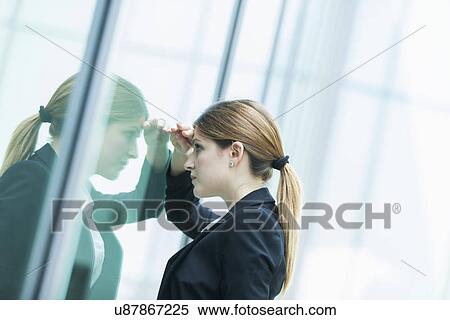 Businesswoman peering through glass window View Large Photo Image Stock Photography - Businesswoman peering through glass window. Fotosearch
