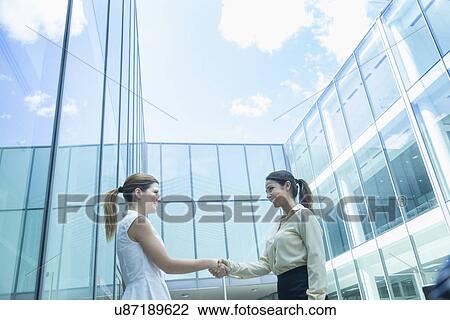 Stock Image - Businesswomen shaking hands. Fotosearch