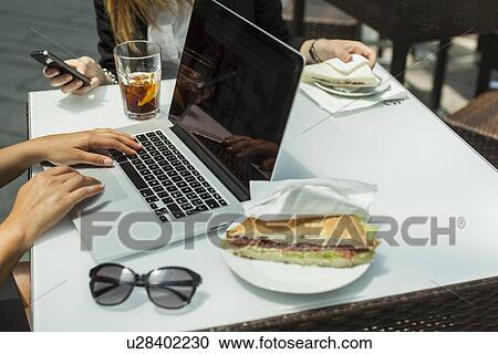 Businesswomen using laptop on working lunch View Large Photo Image Stock Image - Businesswomen using laptop on working lunch. Fotosearch