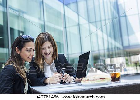 Businesswomen using laptop on working lunch View Large Photo Image Stock Photograph - Businesswomen using laptop on working lunch. Fotosearch