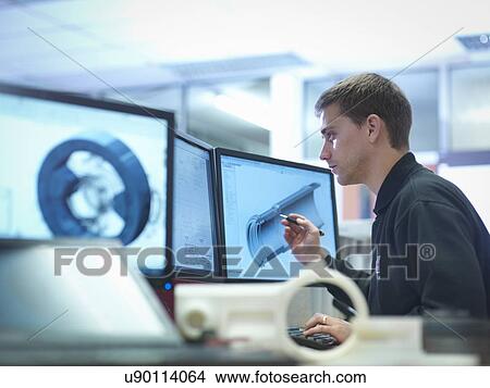 Picture - CAD designer working on engineering designs. Fotosearch