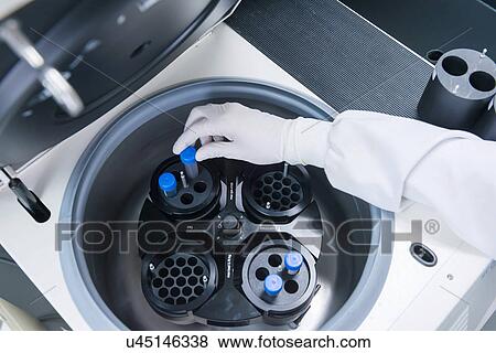Stock Photo - "Cancer research laboratory, hand of scientist placing cells into centrifuge". Fotosearch