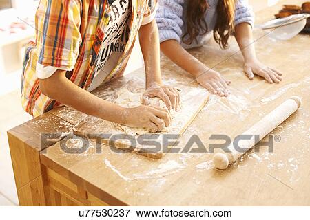 Stock Photo - Children making dough in kitchen. Fotosearch