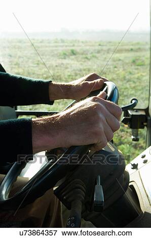 Close up of farmer driving tractor in misty field View Large Photo Image Stock Photo - Close up of farmer driving tractor in misty field. Fotosearch