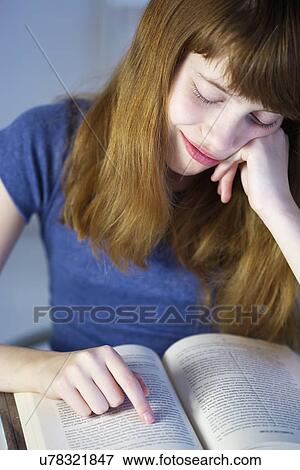 Close up of smiling girl reading book View Large Photo Image Stock Photo - Close up of smiling girl reading book. Fotosearch